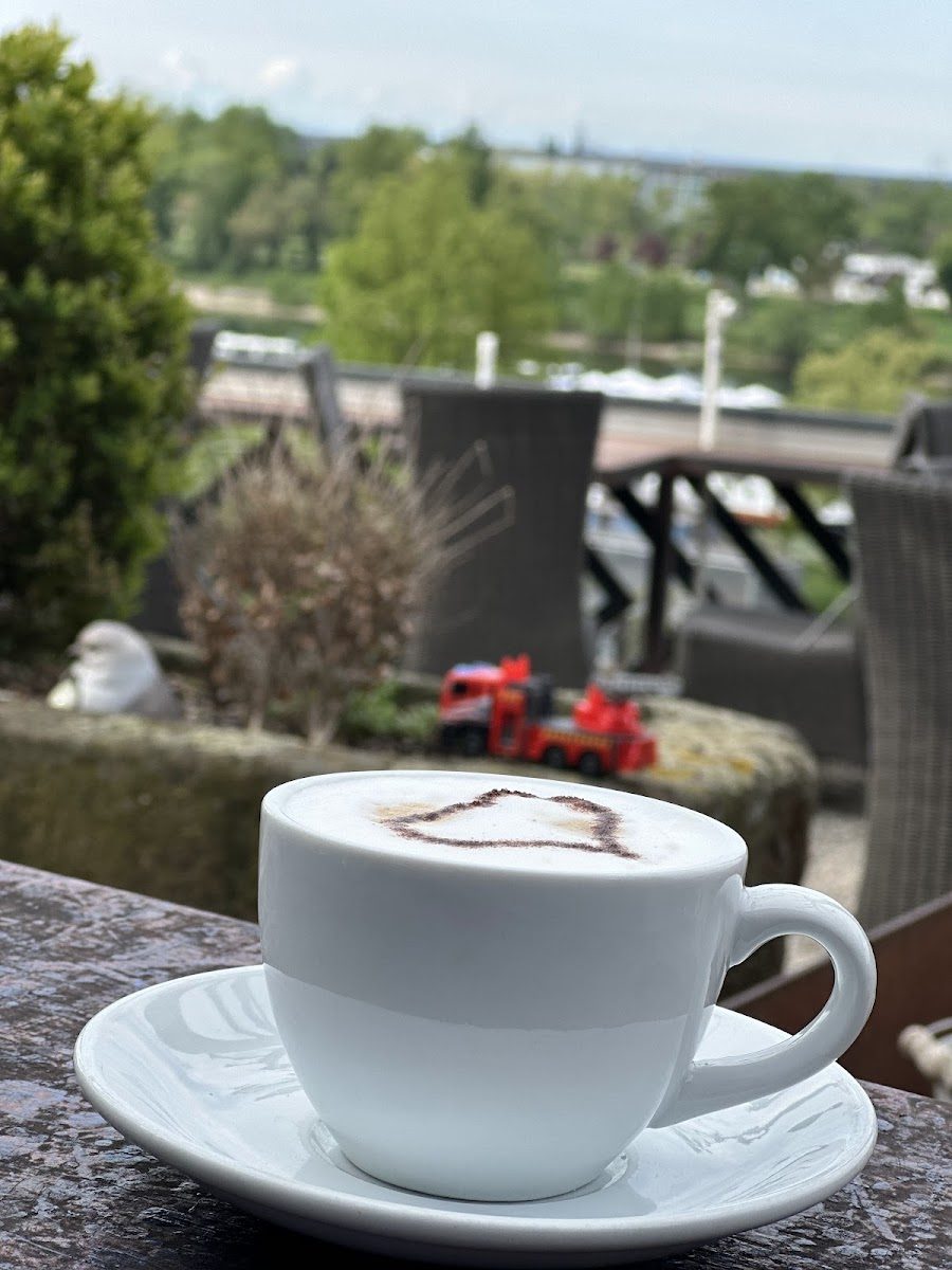 Cappuccino mit Latte-Art auf der Terrasse über dem Rhein